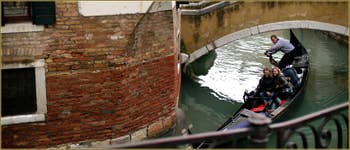 Virage serré en gondole sous le pont privé de Ca' Venier, dans le Sestier du Castello à Venise.