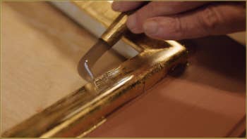 Le polissage de l'or par le maître doreur Gennaro Stolfi, avec un outil se terminant par une pierre d'agate.