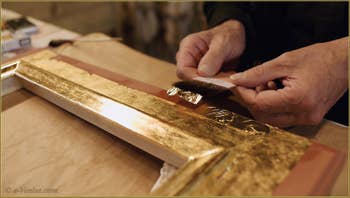 La pose des feuilles d'or sur le cadre par le Maître doreur Gennaro Stolfi.