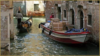 Gondole et péniche de transport vénitienne, sur le rio de San Lio, entre les sestieri du Castello et du Cannaregio à Venise.