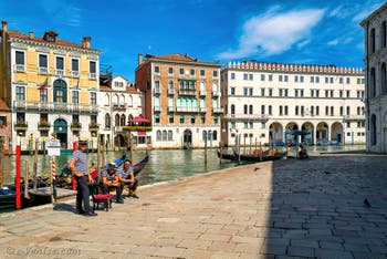 Gondoliers et gondoles sur le Campo de l'Erbaria devant le Grand Canal de Venise, au fond, le Fondaco dei Tedeschi.