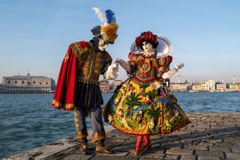 Sur l'île de San Giorgio Maggiore, deux magnifiques costumés aux superbes couleurs avec Blanche Neige et les Septs Nains sur la robe de la princesse du carnaval de Venise.