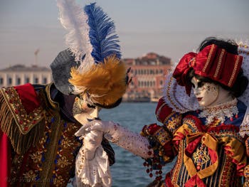 Sur l'île de San Giorgio Maggiore, deux magnifiques costumés aux superbes couleurs avec Blanche Neige et les Septs Nains sur la robe de la princesse du carnaval de Venise.