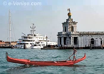 Red gondola in front of the Dogana da Mar in Venice, at the back, modernity...