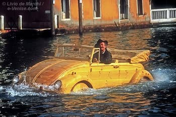 Livio de Marchi dans une volkswagen coccinelle toute en bois sculpté sur le Grand Canal à Venise