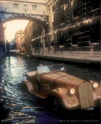 Livio de Marchi sous le pont des Soupirs à Venise au volant d'une Jaguar 1934 en bois sculpté