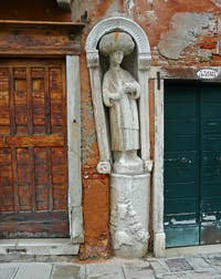 Above, the The statue of the servant of the Mastelli brothers, embedded in the wall of Tintoretto's house, number 3397 on the Fondamenta dei Mori in Venice